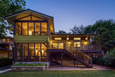 Traditional two-storey yellow house exterior in Austin with concrete fiberboard siding, a gable roof and a metal roof.