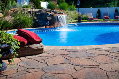 Example of a large classic backyard stone and custom-shaped natural pool fountain design in Cincinnati