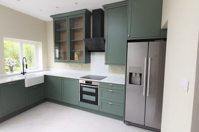 Photo of a medium sized classic l-shaped kitchen/diner in London with shaker cabinets, green cabinets, quartz worktops and no island.
