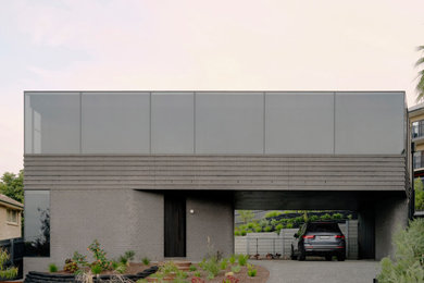 Mittelgroßes, Zweistöckiges Modernes Einfamilienhaus mit Backsteinfassade, schwarzer Fassadenfarbe, Flachdach, Blechdach und schwarzem Dach in Melbourne