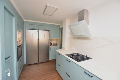Diseño de cocina lineal y blanca y madera clásica renovada extra grande abierta y de nogal sin isla con fregadero bajoencimera, armarios con paneles lisos, puertas de armario azules, encimera de cuarzo compacto, salpicadero multicolor, puertas de cuarzo sintético, electrodomésticos de acero inoxidable, suelo de baldosas de porcelana, suelo marrón, encimeras multicolor y bandeja