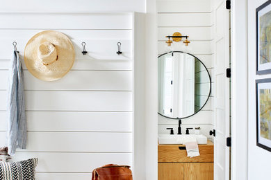 Example of a small danish light wood floor, wood ceiling and shiplap wall entryway design in Atlanta with white walls