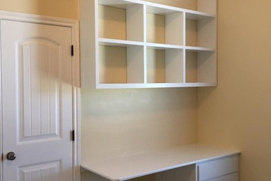 Example of a small transitional built-in desk carpeted and beige floor study room design in Los Angeles with yellow walls