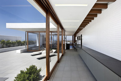 Hallway - large modern concrete floor and gray floor hallway idea in Orange County with white walls