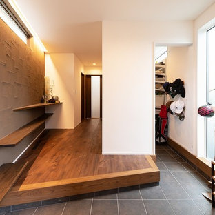 京都のモダンスタイルのおしゃれな玄関ホール (マルチカラーの壁、黒い床) の写真