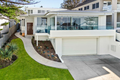 Contemporary two-storey white house exterior in Central Coast with a white roof.