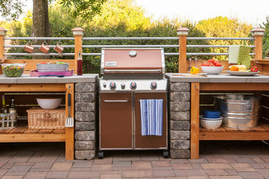 Patio kitchen - small industrial backyard brick patio kitchen idea in Other