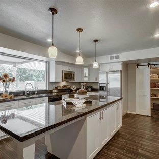 Idéer för ett stort lantligt kök, med en dubbel diskho, skåp i shakerstil, vita skåp, granitbänkskiva, svart stänkskydd, stänkskydd i sten, rostfria vitvaror, klinkergolv i porslin och en köksö