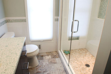 Example of a mid-sized beach style white tile and ceramic tile travertine floor alcove shower design in Minneapolis with an integrated sink, flat-panel cabinets, dark wood cabinets, a two-piece toilet and blue walls
