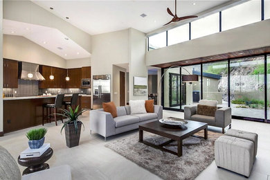 Huge trendy open concept living room photo in Phoenix with a wall-mounted tv, beige walls, a two-sided fireplace and a stone fireplace