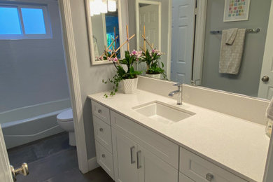 Small trendy kids' gray tile and porcelain tile porcelain tile, gray floor and single-sink bathroom photo in San Luis Obispo with shaker cabinets, white cabinets, a two-piece toilet, gray walls, an undermount sink, quartzite countertops, white countertops and a built-in vanity