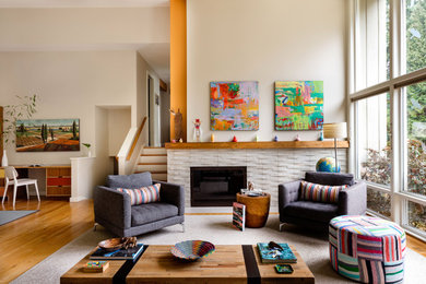 Mid-sized trendy open concept medium tone wood floor and brown floor living room photo in Seattle with a standard fireplace, a stone fireplace, no tv and beige walls