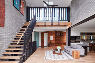 Large trendy open concept light wood floor and beige floor living room photo in Ottawa with gray walls and no fireplace