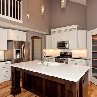 Mid-sized modern kitchen pantry designs - Example of a mid-sized minimalist l-shaped light wood floor kitchen pantry design in Wichita with an undermount sink, shaker cabinets, white cabinets, quartz countertops, white backsplash, subway tile backsplash, stainless steel appliances and an island