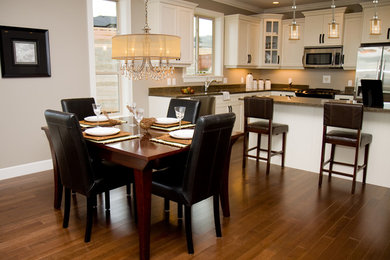 Eat-in kitchen - mid-sized traditional single-wall medium tone wood floor eat-in kitchen idea in New York with an undermount sink, shaker cabinets, white cabinets, marble countertops, gray backsplash, ceramic backsplash, stainless steel appliances and an island