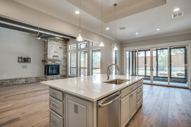Large transitional l-shaped open concept kitchen photo in Dallas with an undermount sink, raised-panel cabinets, gray cabinets, stainless steel appliances and an island