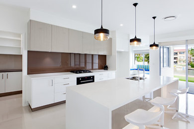 Photo of a large modern galley kitchen pantry in Sunshine Coast with a double-bowl sink, white cabinets, marble benchtops, brown splashback, marble floors and with island.