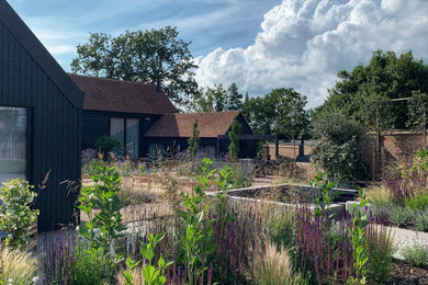 Inspiration for a large contemporary back formal full sun garden for summer in Sussex with brick paving.