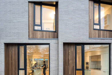 Large modern brown three-story brick townhouse exterior idea in Toronto