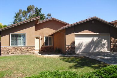 Example of a mid-sized trendy beige one-story stucco gable roof design in San Francisco