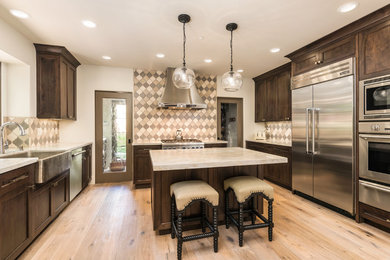 Kitchen - mediterranean u-shaped light wood floor kitchen idea in San Francisco with a farmhouse sink, shaker cabinets, dark wood cabinets, quartzite countertops, multicolored backsplash, stainless steel appliances and an island