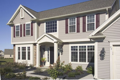 Large traditional gray two-story vinyl house exterior idea in Other with a hip roof and a shingle roof