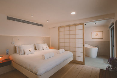 Modernes Gästezimmer mit hellem Holzboden in Sonstige