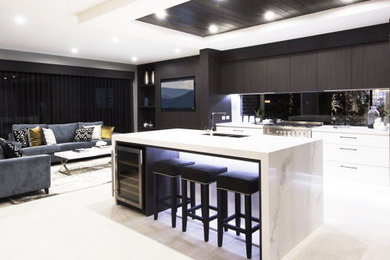 Design ideas for a large modern galley open plan kitchen in Sydney with a double-bowl sink, flat-panel cabinets, white cabinets, marble benchtops, white splashback, with island and white benchtop.