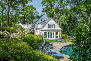 Pool house - large traditional side yard stone and kidney-shaped pool house idea in Boston