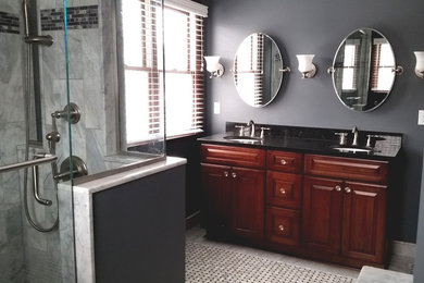Alcove shower - large traditional master white tile and stone tile marble floor and gray floor alcove shower idea in Other with an undermount sink, raised-panel cabinets, medium tone wood cabinets, granite countertops, a two-piece toilet, gray walls and a hinged shower door