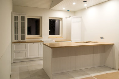 Inspiration for a scandinavian kitchen remodel in Other with a farmhouse sink, white cabinets and wood countertops