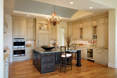 Elegant u-shaped eat-in kitchen photo in Miami with an undermount sink, raised-panel cabinets and beige cabinets