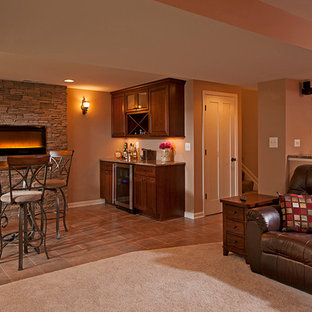 Photo of a classic fully buried basement in Baltimore with beige walls, ceramic flooring, a ribbon fireplace, a stone fireplace surround and orange floors.