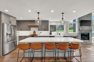 Kitchen - contemporary medium tone wood floor and brown floor kitchen idea in Salt Lake City with a farmhouse sink, shaker cabinets, gray cabinets, quartz countertops, white backsplash, ceramic backsplash, stainless steel appliances, an island and white countertops