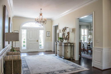 Inspiration for a large transitional dark wood floor and brown floor entryway remodel in Birmingham with beige walls and a white front door