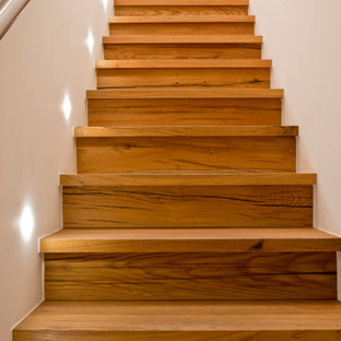 Idée de décoration pour un escalier droit chalet de taille moyenne avec des marches en bois, des contremarches en bois, un garde-corps en métal et un mur en parement de brique.