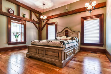 Inspiration for a mid-sized rustic master medium tone wood floor bedroom remodel in Toronto with beige walls and no fireplace