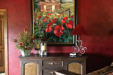 Imagen de dormitorio principal rústico con paredes rojas y suelo de madera en tonos medios