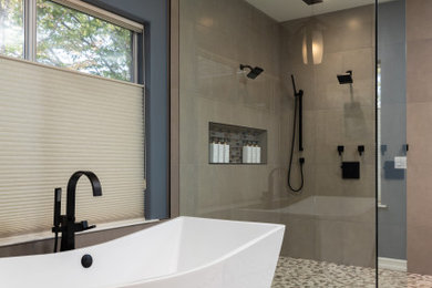 Huge trendy master beige tile and porcelain tile pebble tile floor, multicolored floor and double-sink bathroom photo in Other with raised-panel cabinets, brown cabinets, blue walls, an undermount sink, quartzite countertops, a hinged shower door, gray countertops, a niche and a built-in vanity