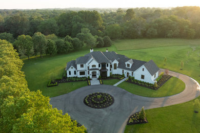 Example of a large minimalist white two-story stucco house exterior design in Philadelphia with a hip roof, a mixed material roof and a black roof
