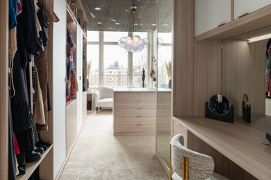 Inspiration for a huge modern women's carpeted and beige floor walk-in closet remodel in New York with flat-panel cabinets and beige cabinets
