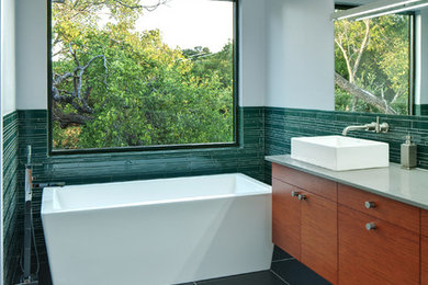 This is an example of a modern bathroom in Austin with a freestanding tub and a vessel sink.