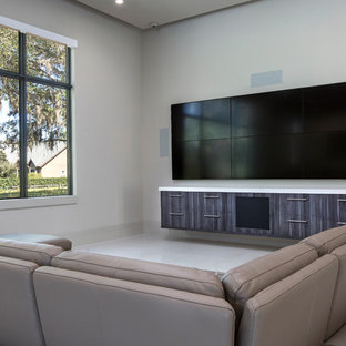 Cette image montre une salle de cinéma minimaliste de taille moyenne et ouverte avec un mur blanc, un sol en calcaire, un téléviseur fixé au mur et un sol blanc.