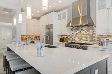 This is an example of a contemporary single-wall open plan kitchen in Miami with white cabinets, quartzite benchtops, multi-coloured splashback, ceramic splashback, stainless steel appliances and with island.