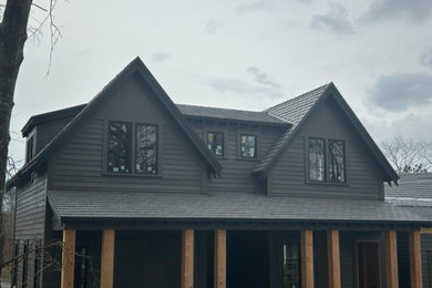 Modelo de fachada de casa multicolor y negra nórdica extra grande de tres plantas con revestimiento de piedra y tejado a dos aguas