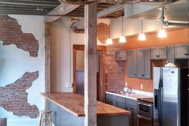 Mid-sized mountain style galley light wood floor eat-in kitchen photo in Other with an undermount sink, recessed-panel cabinets, gray cabinets, quartz countertops, stainless steel appliances and a peninsula