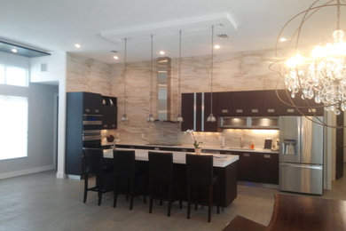 Example of a large minimalist l-shaped open concept kitchen design in Tampa with an undermount sink, flat-panel cabinets, dark wood cabinets, quartzite countertops, brown backsplash, stone slab backsplash, stainless steel appliances and an island