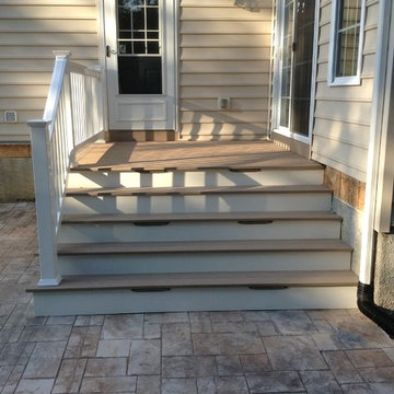Small 8'x8' deck with enlarged stairs down to Stamped Concrete Patio