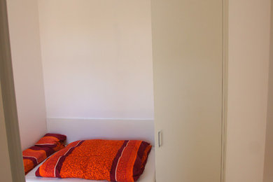 Foto de dormitorio principal bohemio pequeño con paredes blancas, suelo de madera clara y suelo beige
