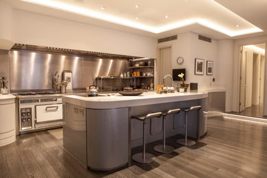 Design ideas for a medium sized contemporary grey and white u-shaped open plan kitchen in London with a built-in sink, open cabinets, light wood cabinets, marble worktops, metallic splashback, integrated appliances, light hardwood flooring, multiple islands, grey floors, white worktops, a coffered ceiling and a feature wall.